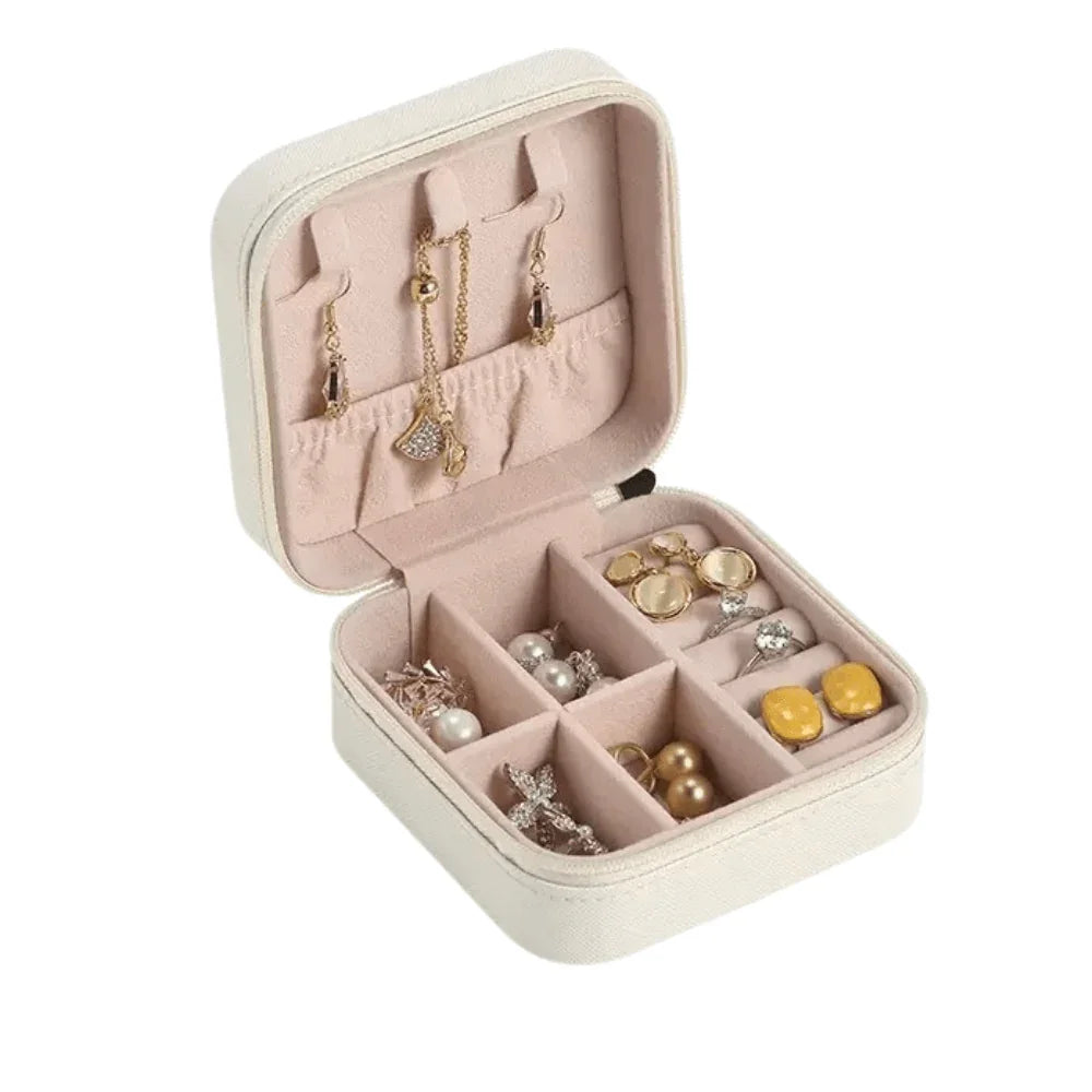 Open jewelry box with compartments filled with various earrings on a white background