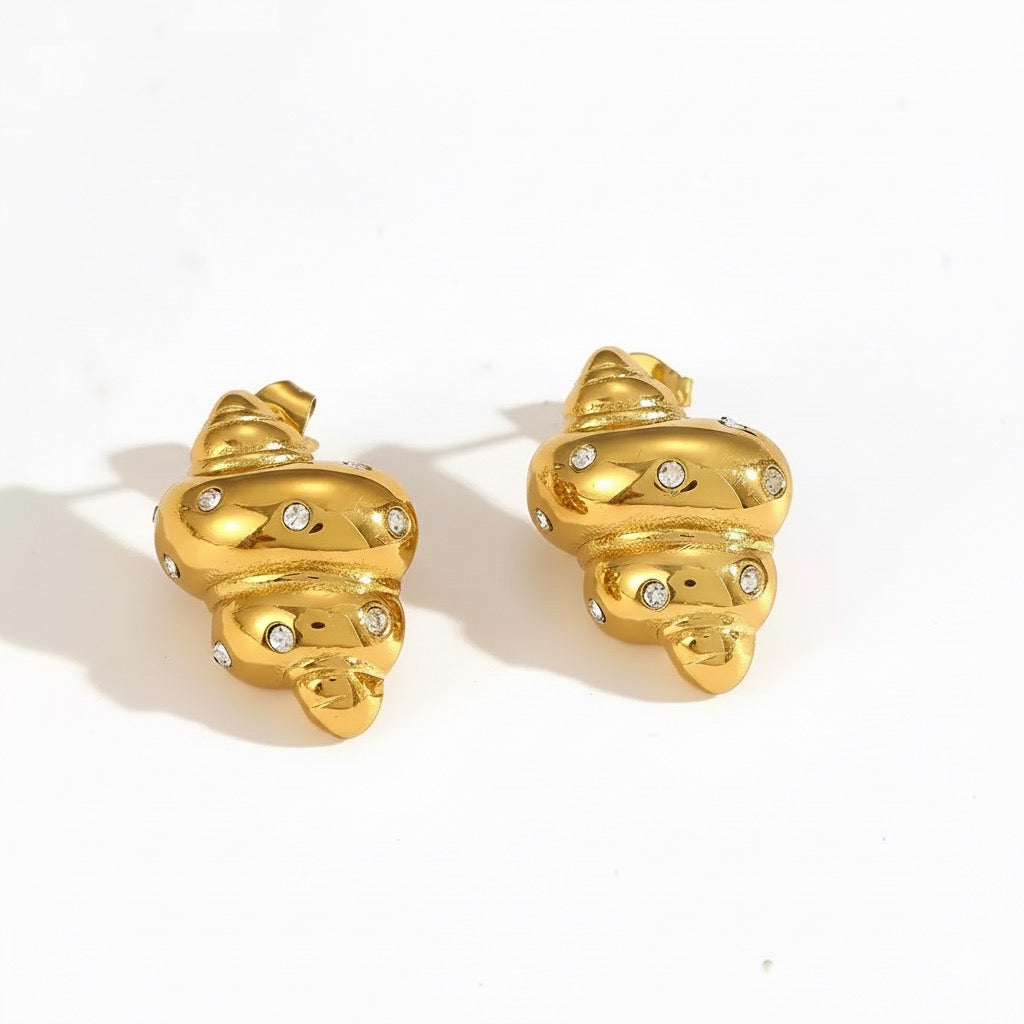 Gold shell-shaped earrings with embedded stones on a white background