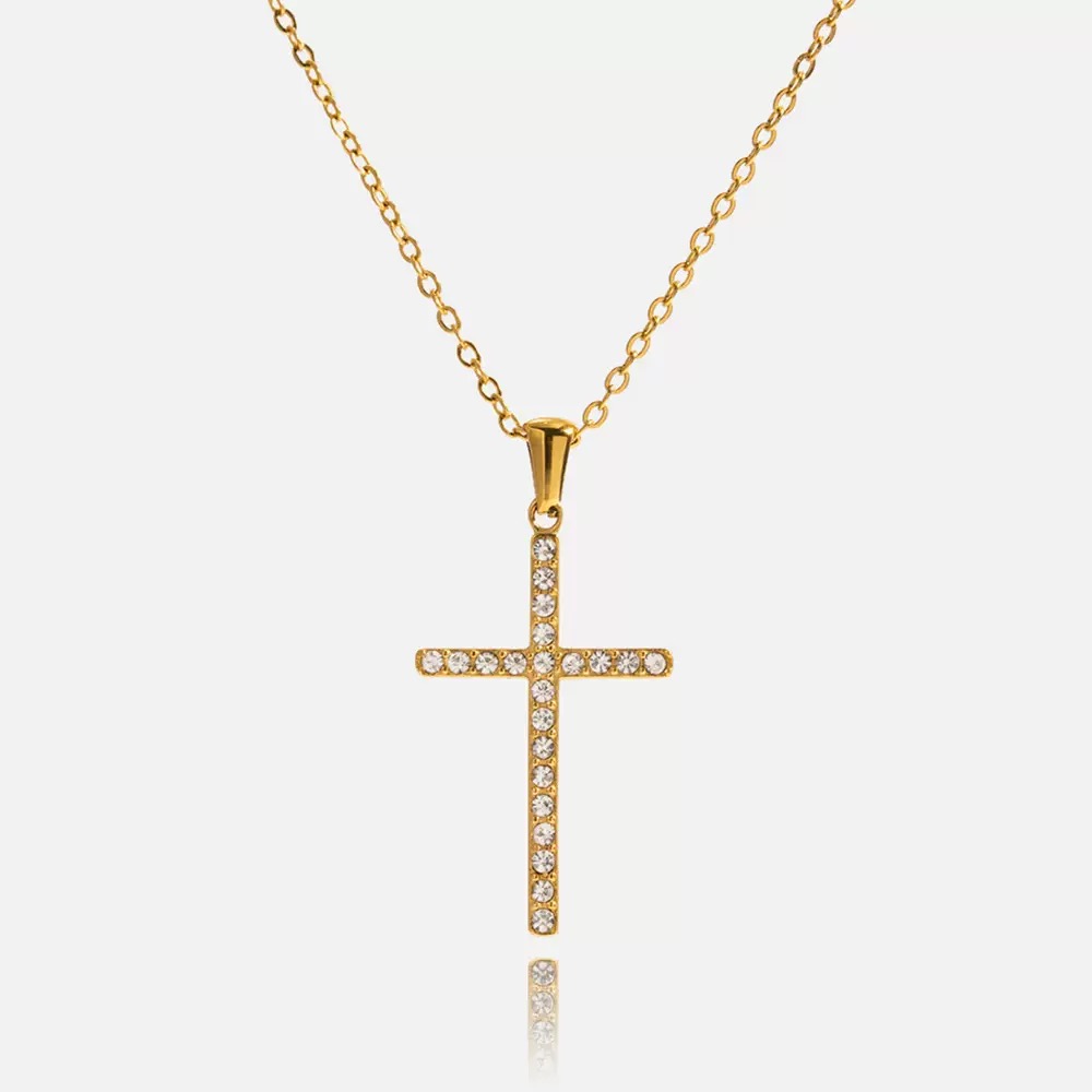 Gold cross necklace with clear stones on a white background