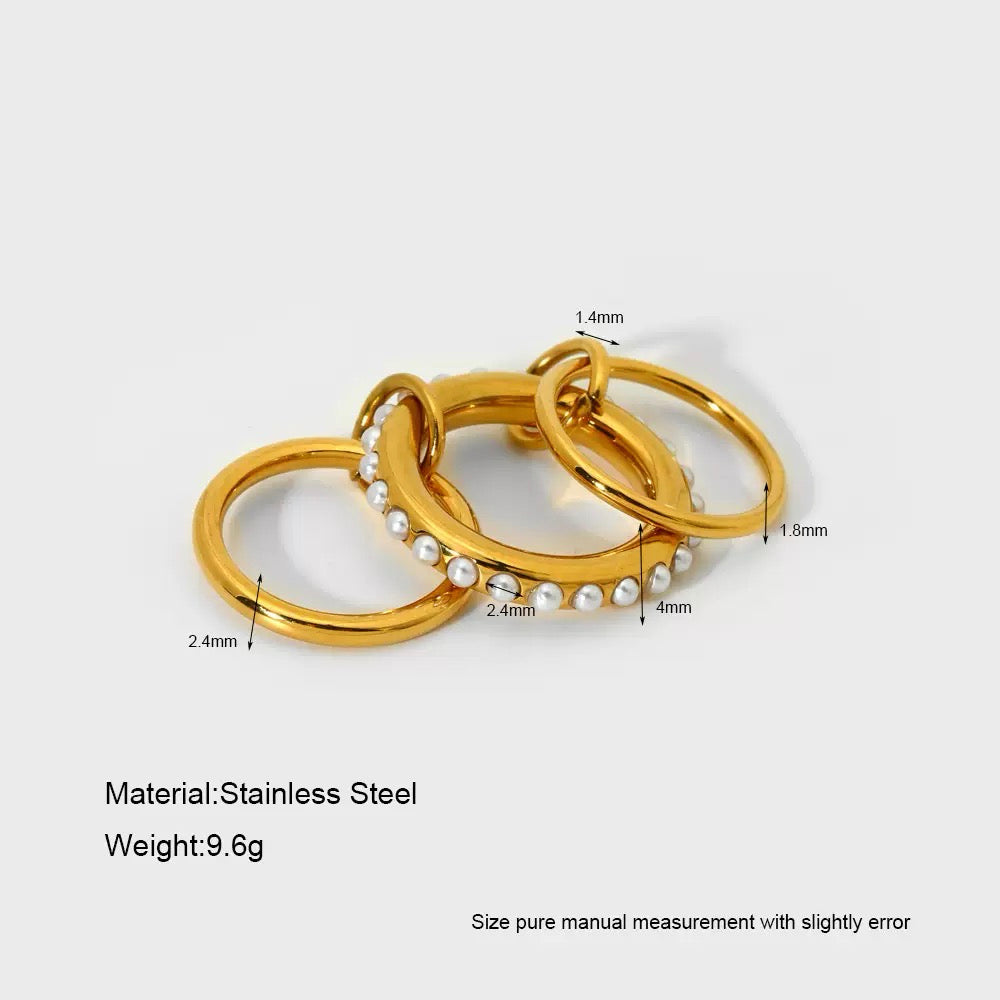 Gold rings with pearl beads and measurements on a white background