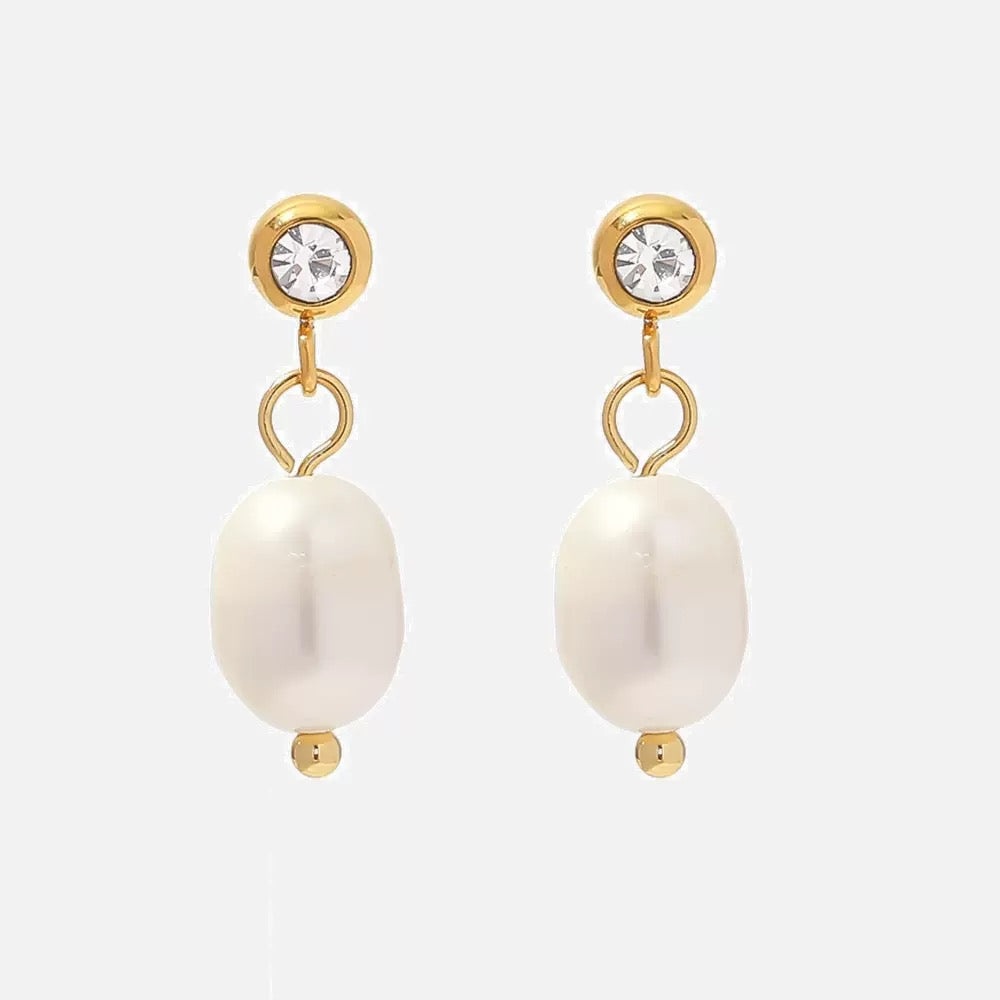Pair of pearl earrings with gold accents on a white background