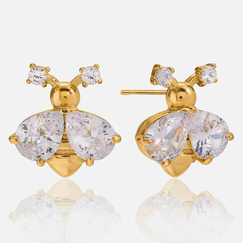 Gold bee-shaped earrings with clear gemstones on a white background