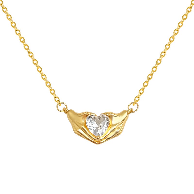 Gold necklace with a heart-shaped pendant on a white background