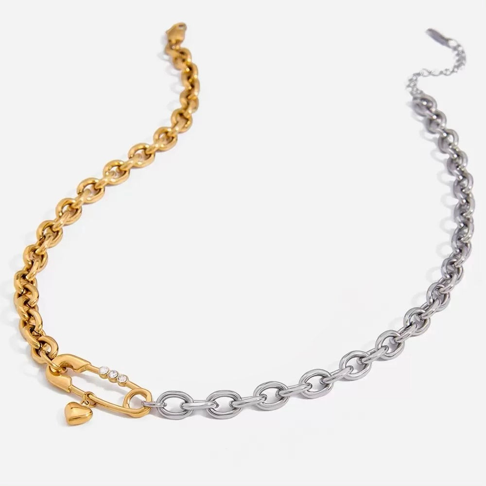 Gold and silver chain bracelet with heart and lock charm on a white background
