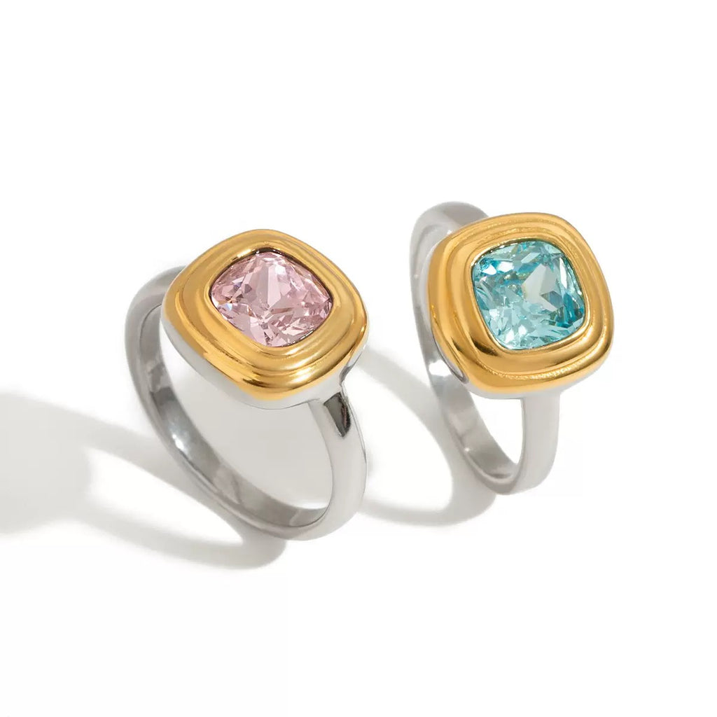 Two rings with gold and silver bands and gemstones on a white background