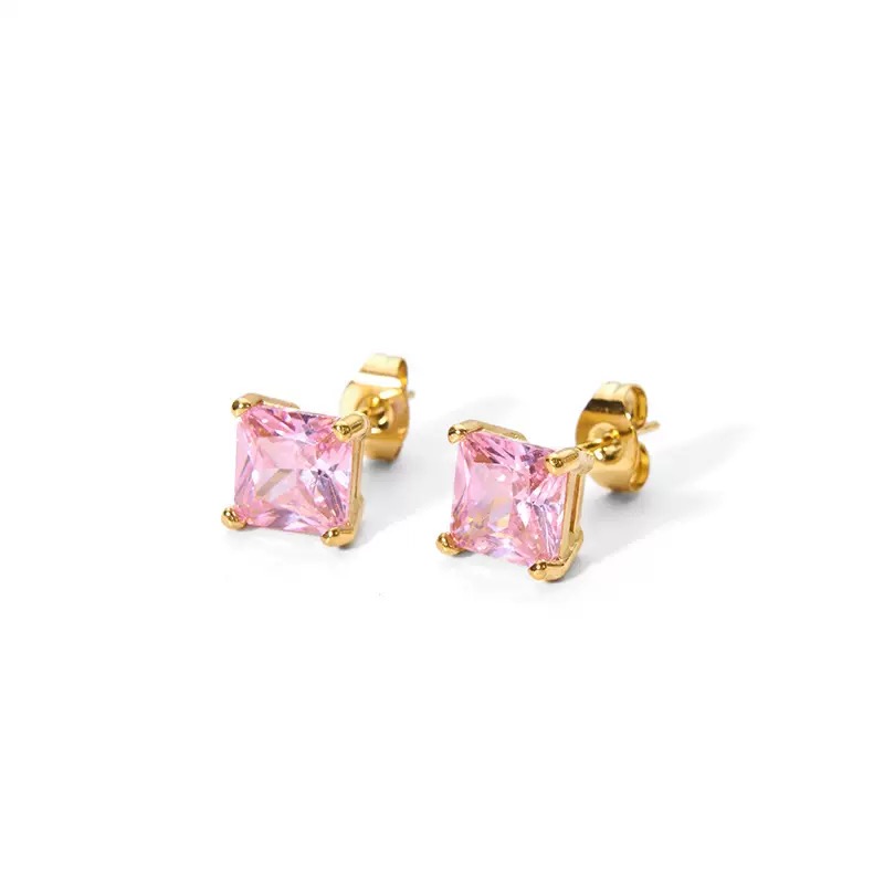 Gold earrings with pink gemstones on a white background
