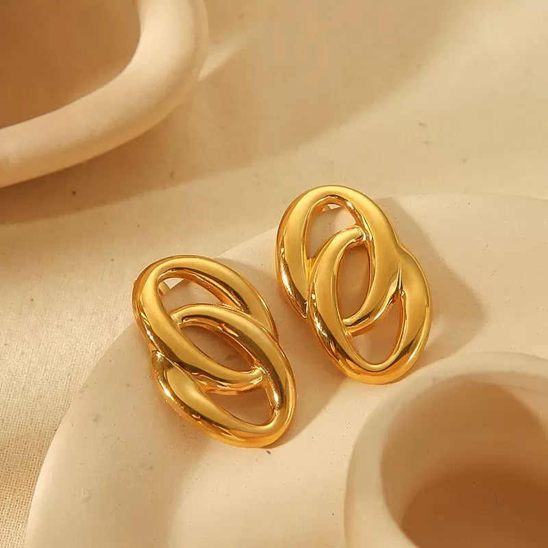 Pair of gold earrings on a beige background
