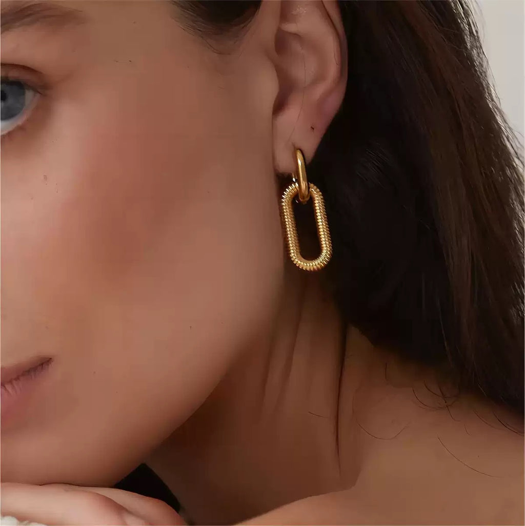 Close-up of a person wearing a gold hoop earring.
