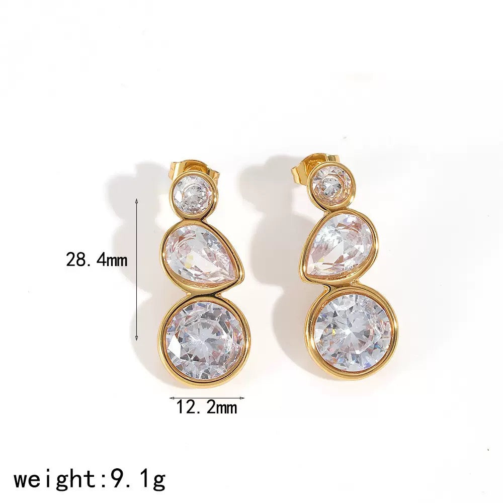 Gold earrings with clear gemstones on a white background, showing measurements and weight.