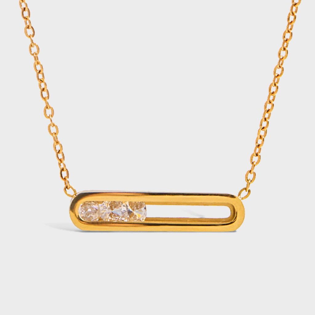 Gold necklace with a rectangular pendant on a light gray background