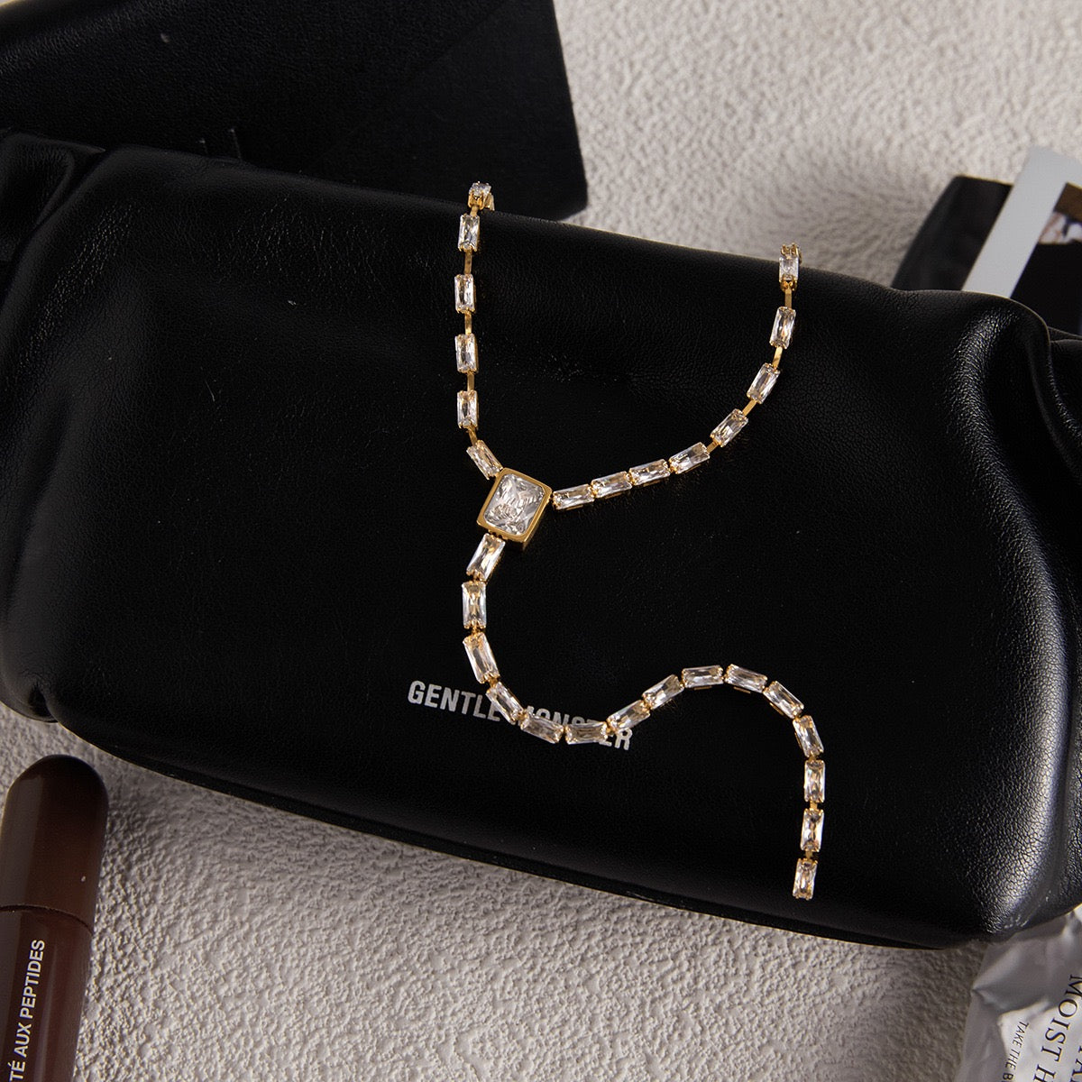 Gold necklace with crystals on a black handbag