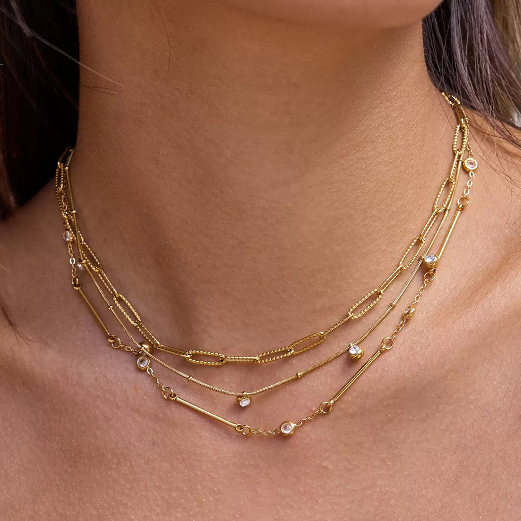 Gold necklace with multiple strands on a person's neck