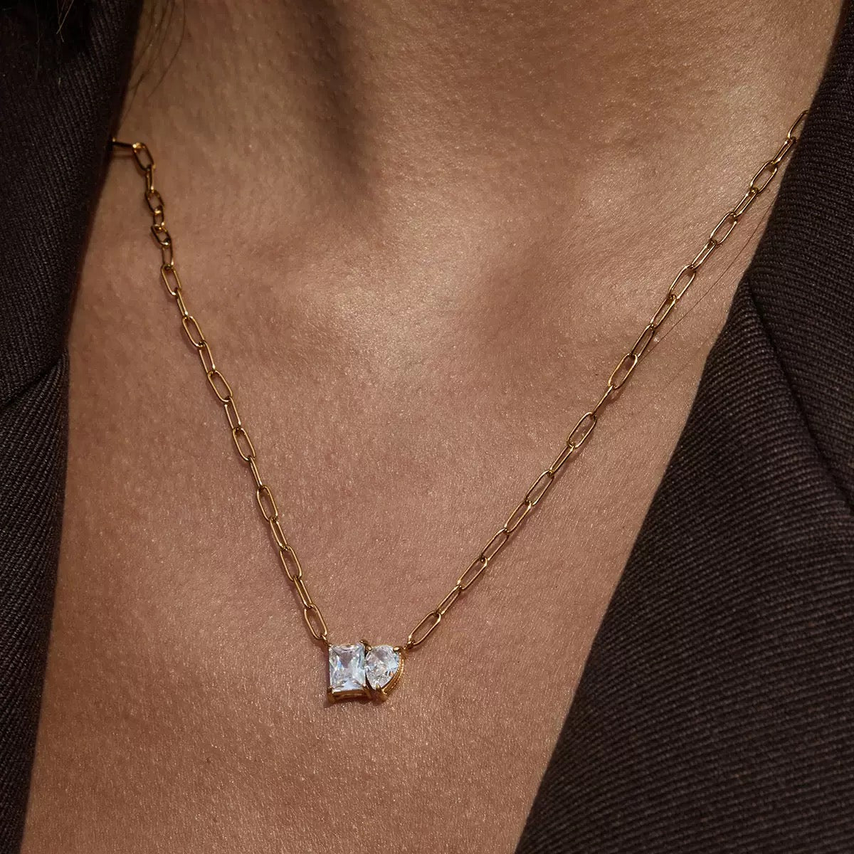 Gold chain necklace with a square pendant on a person's neck
