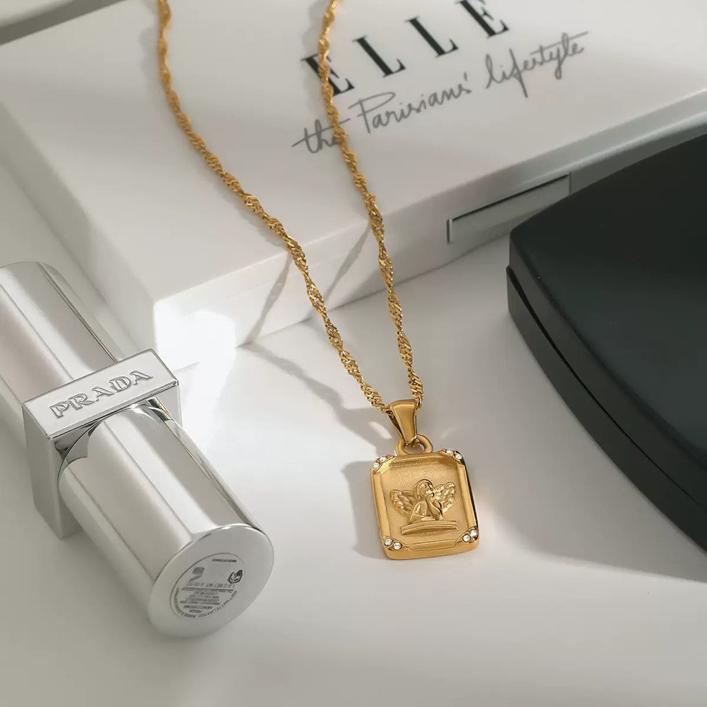 Gold necklace with a pendant on a Prada box