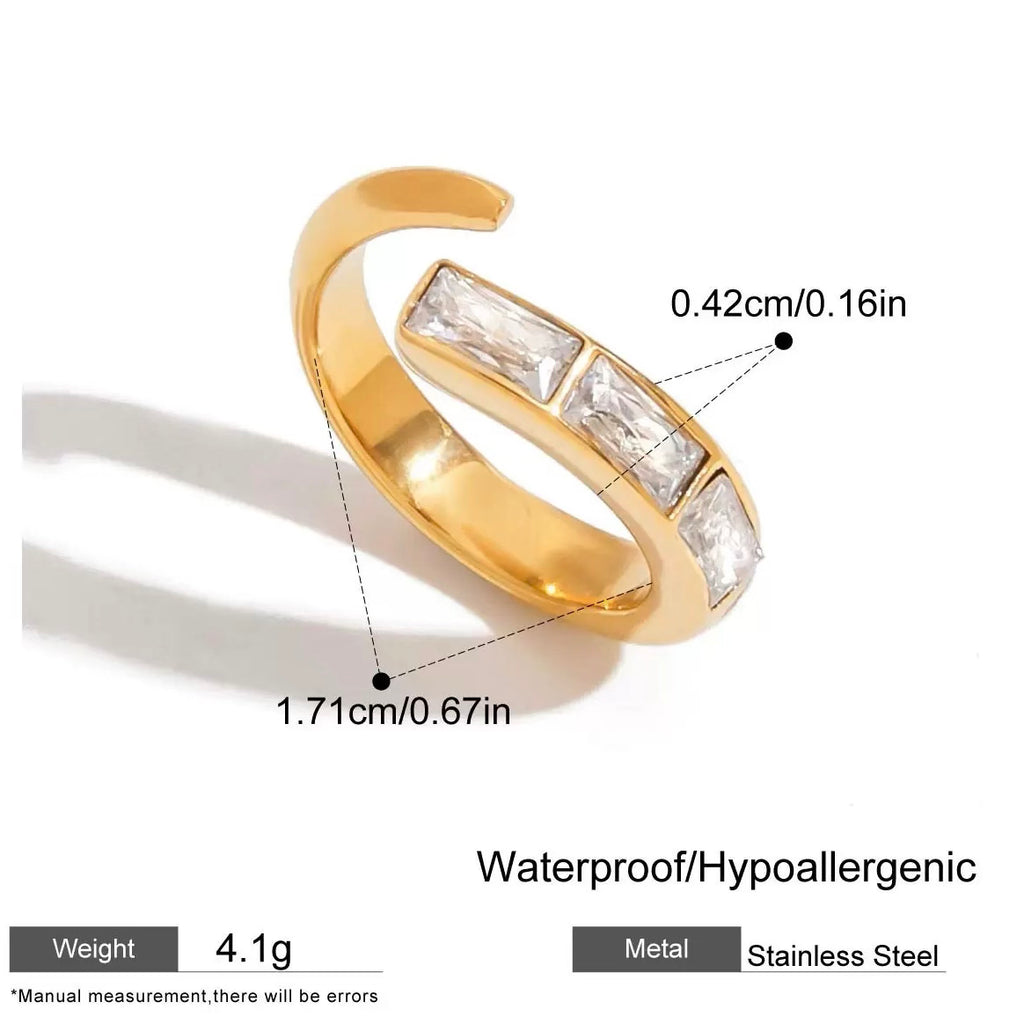 Gold ring with gemstones and measurements on a white background