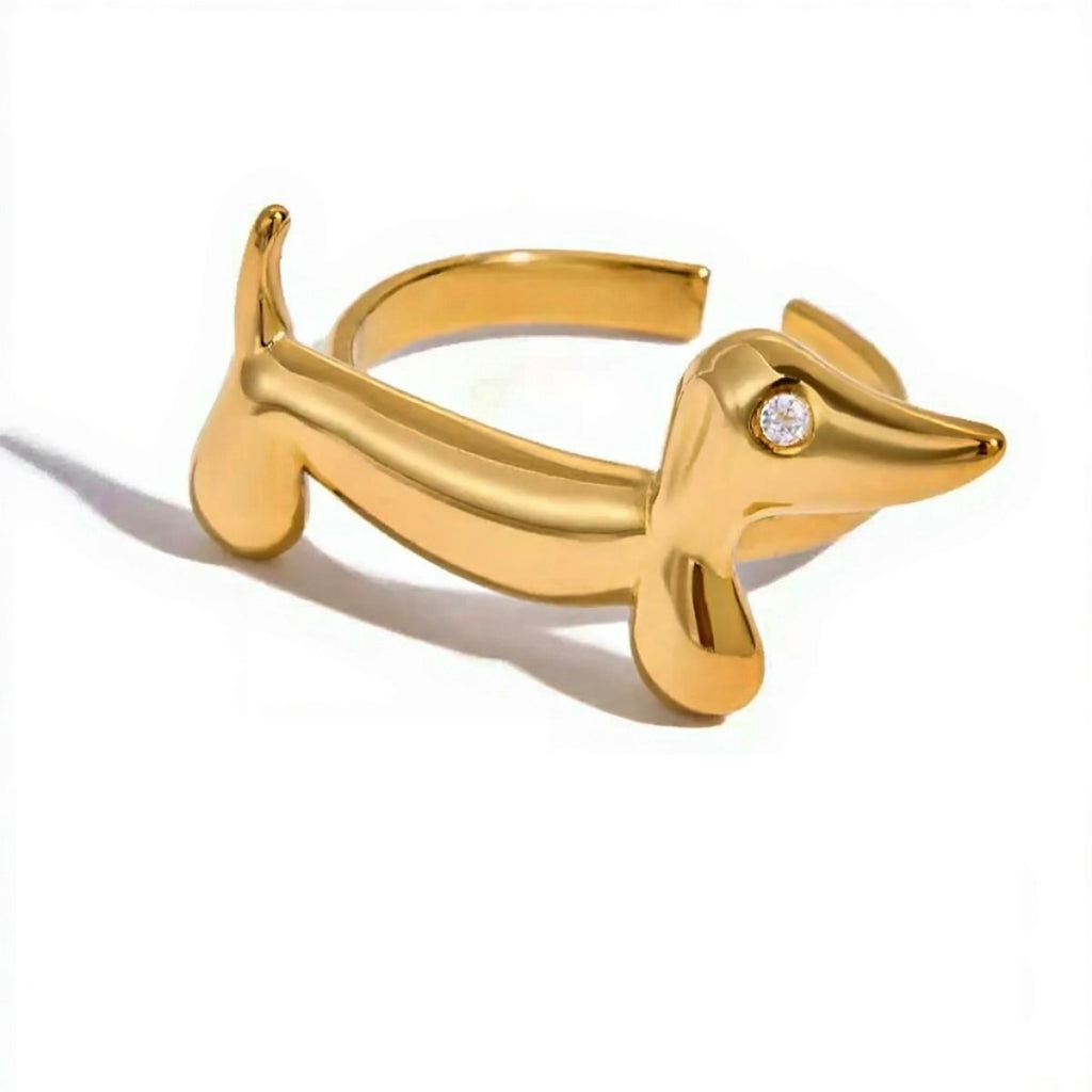 Gold dachshund-shaped ring with a diamond on a white background
