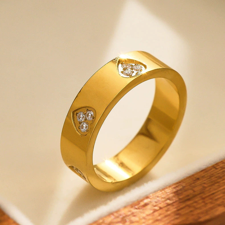 Gold ring with diamond accents on a wooden surface
