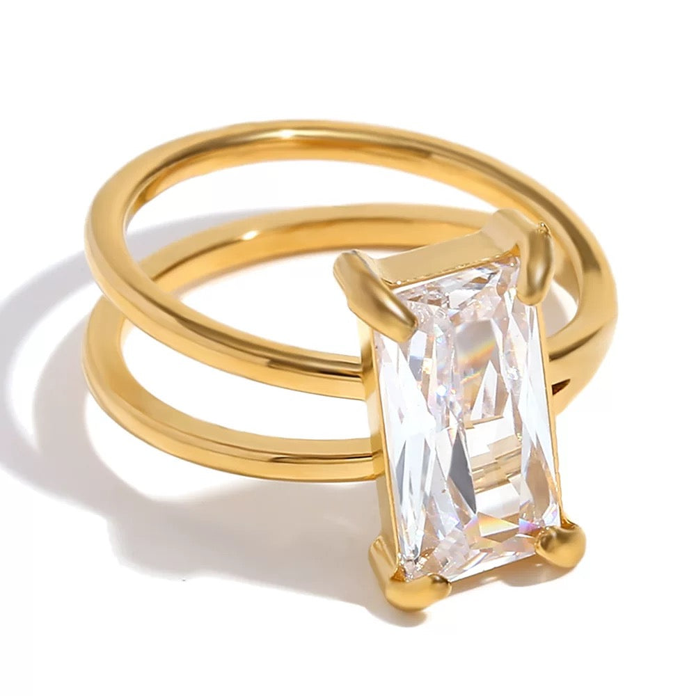 Gold ring with a large diamond on a white background