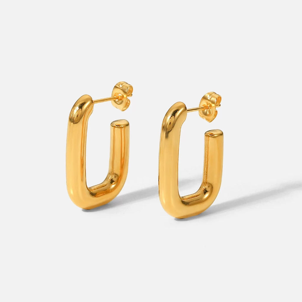 Gold hoop earrings on a light gray background