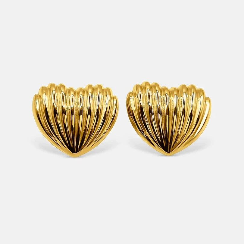 Pair of gold heart-shaped earrings on a light gray background