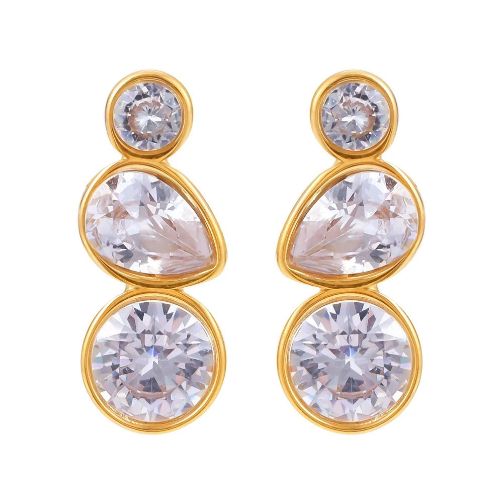 Gold earrings with clear gemstones on a white background