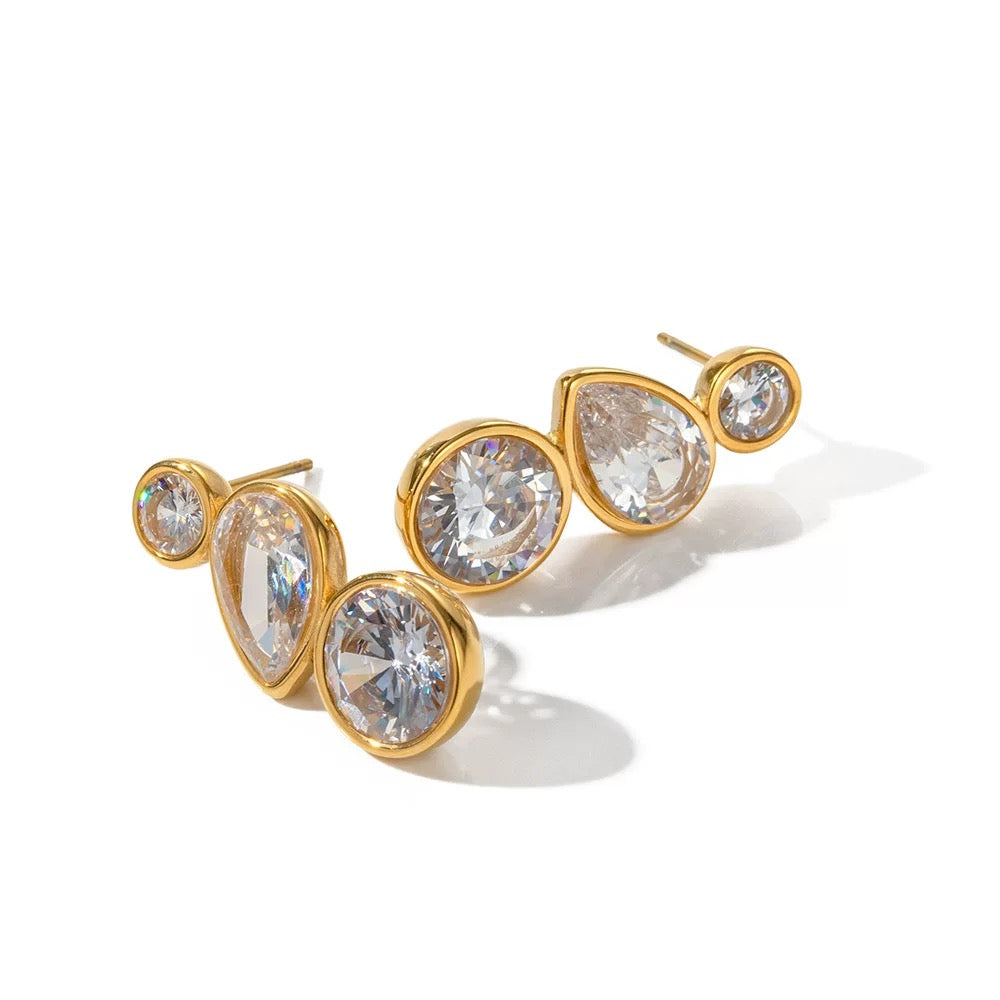 Gold earrings with clear gemstones on a white background